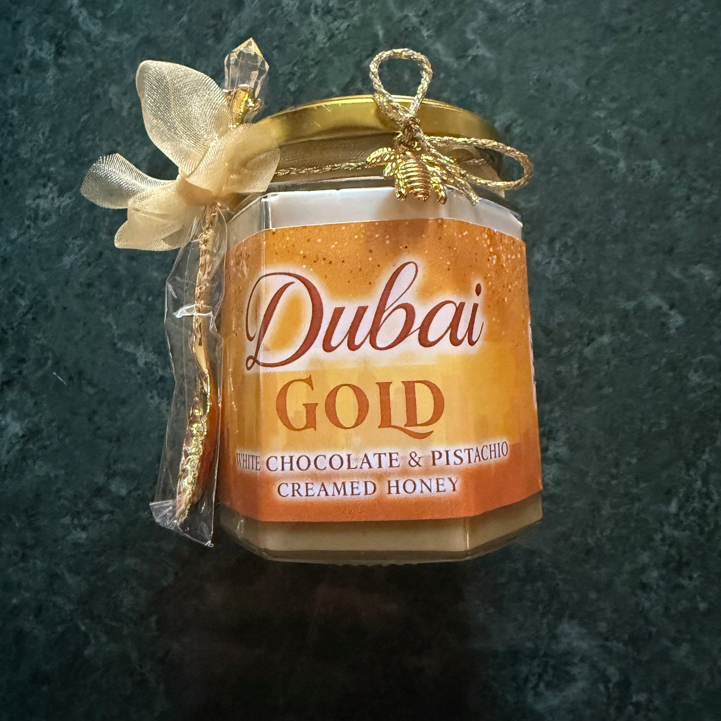 Elegant product flat lay of Dubai Chocolate Bar Creamed Honey trio with tea, biscuits, and floral garnish for luxury dessert pairing