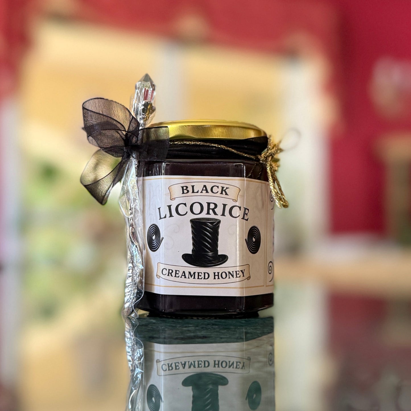 Black Licorice Creamed Honey jar with gold spoon, chiffon ribbon, and bee charm—perfect for licorice lover gifts.