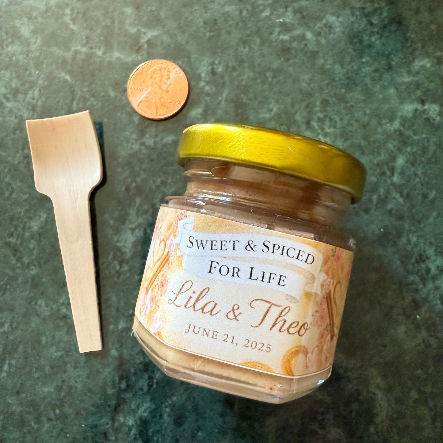 Close-up of custom wedding label on a cinnamon creamed honey jar, featuring names and wedding date in elegant script.