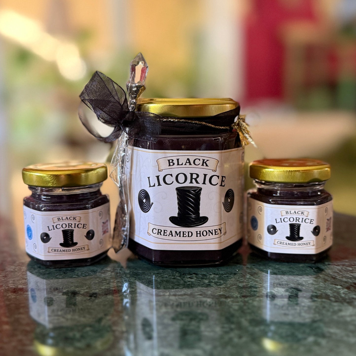 Gourmet licorice honey gift set unwrapped to show gold ribbon, spoon, and presentation details.