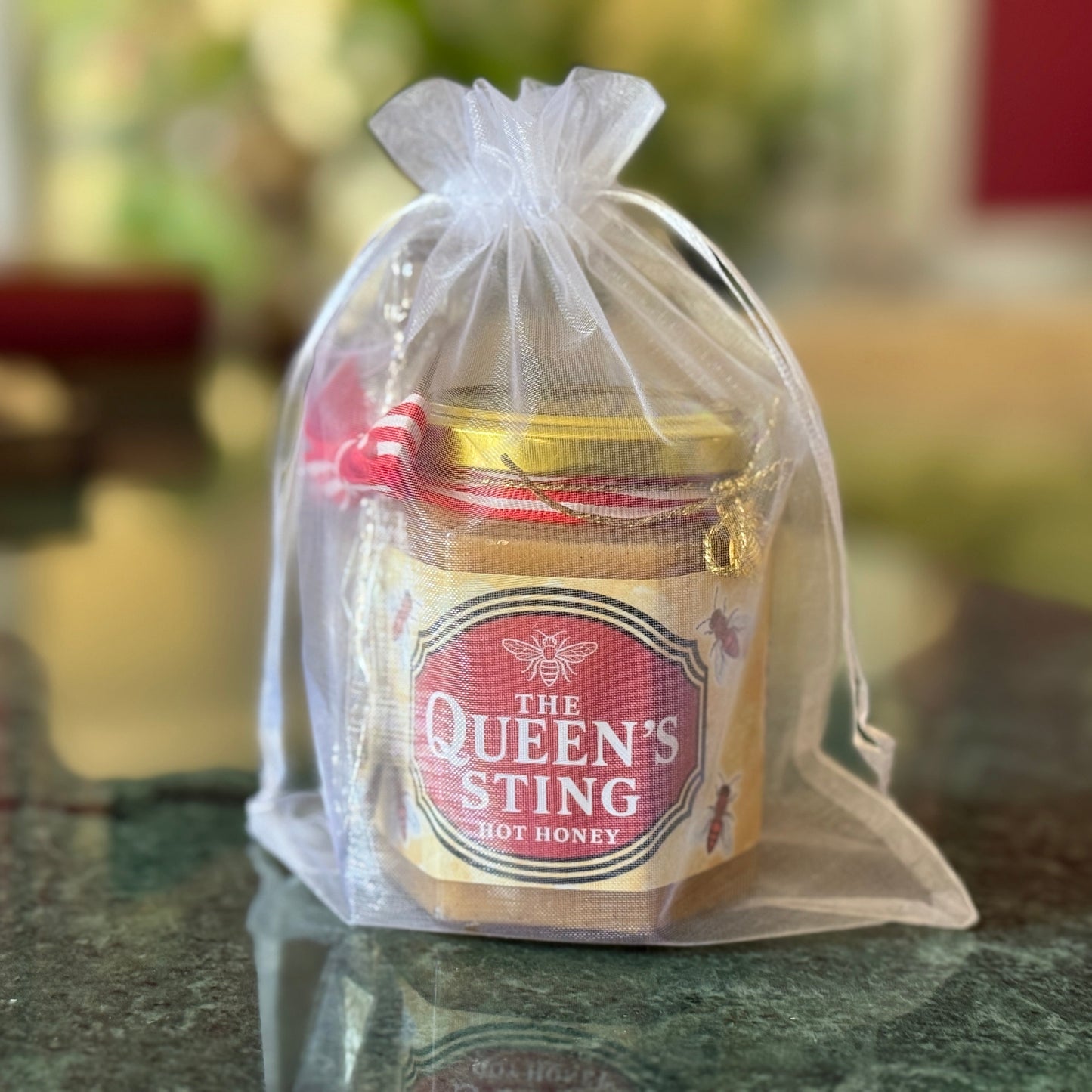 The Queen’s Sting honey gift set displayed with cocktails and rustic tableware