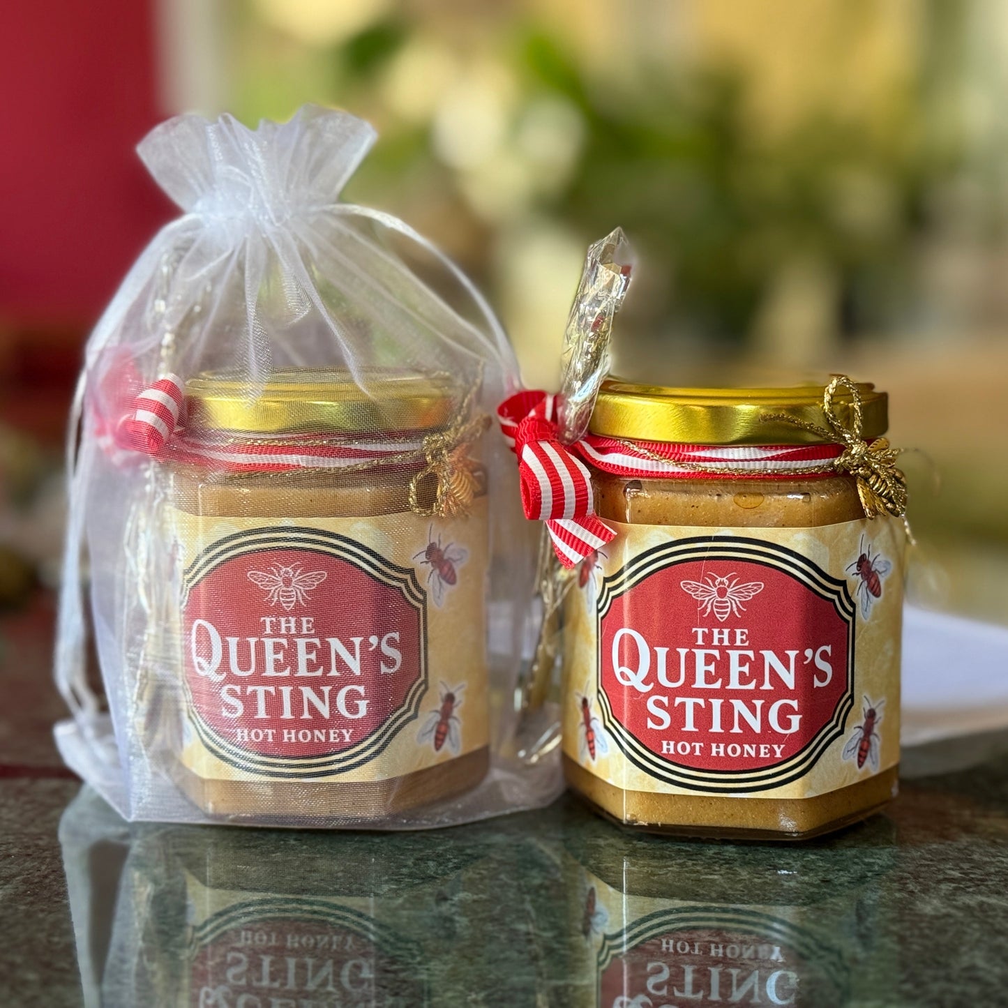 The Queen’s Sting spicy hot honey in sheer organza bag with ribbon and spoon – gourmet gift presentation