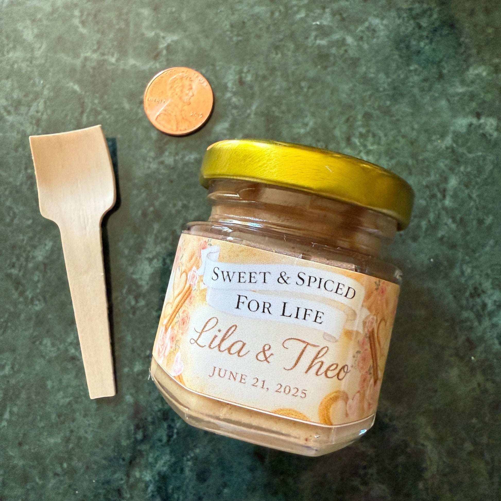 Close-up of custom wedding label on a cinnamon creamed honey jar, featuring names and wedding date in elegant script.